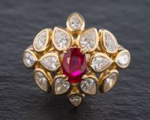 A ruby and diamond cluster ring,: the central oval cut ruby estimated to weigh 1.