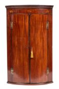 A George III mahogany bowfront corner cabinet.