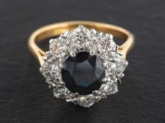 An 18ct gold, sapphire and round, brilliant-cut diamond cluster ring,: estimated sapphire weight ca.