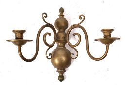 A brass half-round wall mounted twin-branch light bracket: in the early 18th Century Dutch taste,