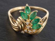 A navette-shaped emerald and diamond cluster ring,: stamped '14K', length of ring head ca. 1.