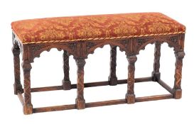 A carved oak and upholstered long stool in Gothic taste, late 19th / early 20th century,