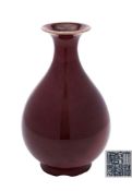 A Chinese sang-de-boeuf bottle vase: the pear-shaped body and flared rim covered in a rich oxblood