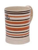 An early 19th century pearlware cylindrical mug: with mocha decoration of black and brown banding