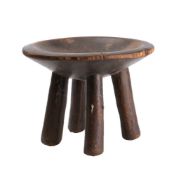 An African carved wooden stool: with circular dished seat raised on four peg feet, 27cm diameter.