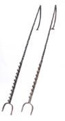 A pair of cob irons:, each with spiral uprights and hinged tops, one iron with ten hooks,