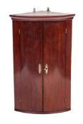 A George III mahogany hanging corner cabinet, last quarter 18th century,