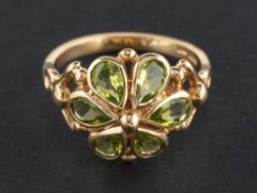 A 9ct gold, peridot, flowerhead ring,: estimated total peridot weight ca. 1.
