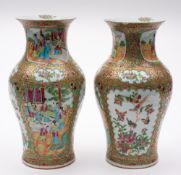 A pair of Chinese Canton famille rose/verte baluster vases: enamelled with shaped panels of figures