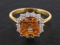 An 18ct gold, octagonal step-cut, brownish orange topaz and round,