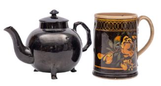 A Jackfield black glazed teapot and cover and a creamware black and brown glazed mug: the teapot of