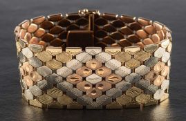 A tri-colour 9ct gold, foliate engraved, fancy-link bracelet,: with London import marks, 1972,
