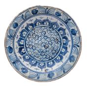 An Isnik blue and white dish: painted with a cell-style medallion within a lappet band and floral