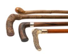A group of four assorted walking canes: one silver mounted, another with gold collar.