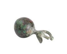 A cast bronze weight : of circular design surmounted by a bird symbol circa C6th BC