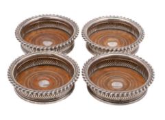 A set of four George III silver wine coasters, maker John Watson & Son, Sheffield, 1819: crested,