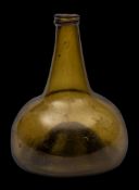 An early 18th century green glass wine bottle: of onion shape with applied neck ring, 17cm.