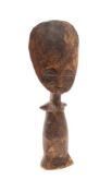 An Ashanti Akua-ba figure: of stylised design with large circular head and tapering body, 28.