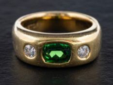 A three-stone, synthetic, green spinel and round, brilliant-cut diamond ring,
