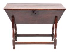 A George II oak dough bin, circa 1730,: with hinged rectangular top above the canted front,