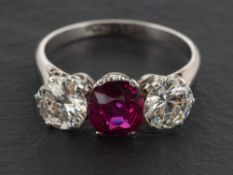 A round, brilliant-cut diamond and ruby three-stone ring,: estimated total diamond weight ca. 1.