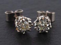 A pair of round, brilliant-cut diamond ear studs,: estimated total diamond weight ca. 0.