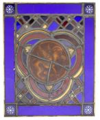 A stained glass panel: the centre decorated with a winged lion,
