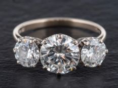 An 18ct gold, round brilliant-cut diamond, three stone ring,: total estimated diamond weight ca.