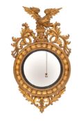 A Regency carved and giltwood framed convex wall mirror, circa 1815,