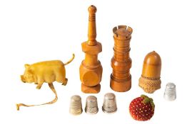 A small group of sewing collectables: including a treen needle case in the form of a chess castle,