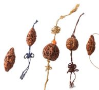 A group of five Chinese carved and pierced hediao nut beads: carved with figures,