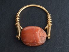A carved carnelian scarab ring,: the ring stamped '750', length of ring head ca. 2.