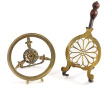 A 19th Century brass mounted iron trivet: with pierced flowerhead design, having turned wood handle,