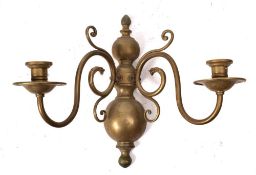 A brass half-round wall mounted twin-branch light bracket: in the early 18th Century Dutch taste,