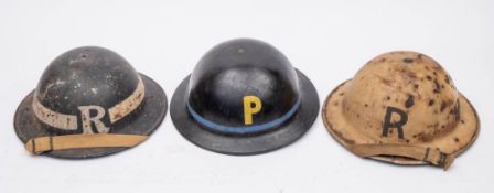 Two WWII MK I steel helmets: one in black with 'R' and rank stripe,