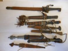 Eight assorted African and other daggers: most in leather sheaths.
