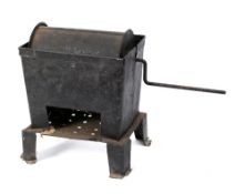 A tin coffee roaster: with 22cm hand operated barrel, in a metal container with draining holes.