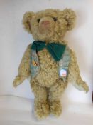 A large pale plush teddy bear with rounded wide-apart ears, black button eyes, stitched snout,