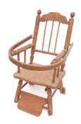 A child's beechwood elbow chair: the back with shaped top rail and spindle uprights,