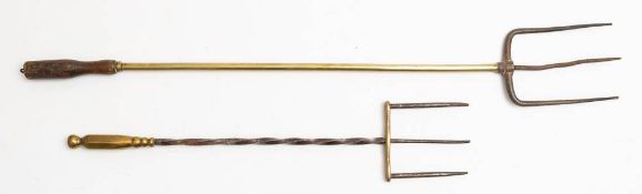 A metal and brass three pronged fork: with spiral stem and polygonal handle and a metal and brass