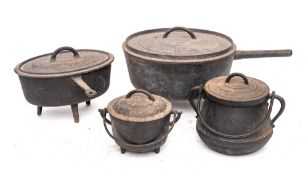A circular iron cooking pot and cover: on tripod feet, 32cm diameter, another oval with cover, 27cm,