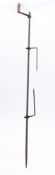 A hand driven iron spit: with twin tines, having turned wood handle, 210cm long.