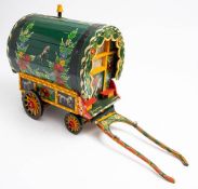 A scratch built model of a gypsy caravan: in green with floral and equestrian decoration,