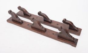 An oak wall mounted spit rack: with three hooks, 53.5cm.