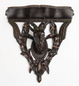 A late 19th/early 20th century Black forest carved wood wall bracket: the shaped open shelf on a
