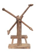 A rustic hoist:, the four spurs operated by a shaped handle, on a trestle base, 37cm across.