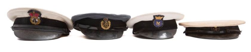 A RAF peaked cap, together with three Royal Navy peaked caps.