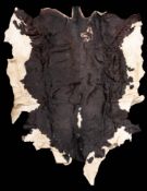 A large black and white cow skin: 226 x 170cm.