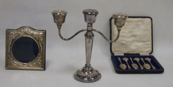 A silver picture frame, a cased set of six spoons and a three light candelabrum, the frame with