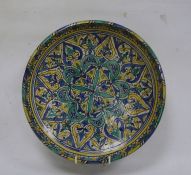 Moroccan pottery charger, late 19th/early 20th century, painted in turquoise, blue and yellow with